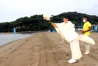 海の安全を祈願する神栄浩郷宮司（左）＝的形海水浴場