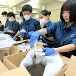 使い捨てカイロの中身を取り出す生徒＝姫路工業高校