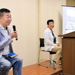 西島の写真を示しながら、物語の背景について説明する鄭義信さん（左）＝姫路市総社本町