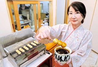 丁寧に焼き上げたみたらし団子を持つ木地美紀子店長＝姫路市二階町