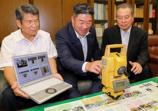 松浦弘幹校長（右）に測量機器の使い方を教える勝間功雄代表（中央）と増田和仁副会長＝龍野北高校