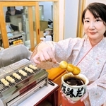 丁寧に焼き上げたみたらし団子を持つ木地美紀子店長＝姫路市二階町