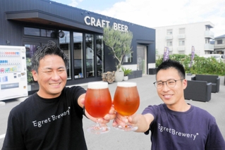 金賞に輝いたビールを手にするイーグレブルワリーの池内正雄さん（左）と入山航さん＝姫路市苫編