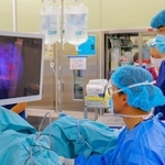 光線力学診断を取り入れ、ぼうこうがんの内視鏡手術をする医師たち。病変が赤く発光している（姫路赤十字病院提供）