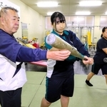 神田吉輝監督（左端）からスイングを教わる高畑采美さん（中央）、矢野彩星さん＝姫路別所高