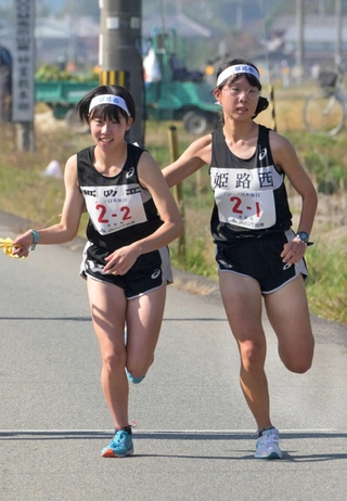 女子・姫路西の１区渡辺晴香選手（右）からたすきを受け取る２区肥塚暖歌選手＝丹波篠山市内（撮影・風斗雅博）