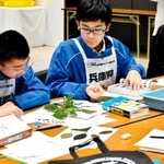 植物の和名などを問う問題に取り組む大久保中学校の生徒ら＝アクリエひめじ