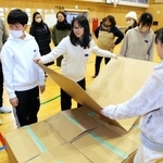 体育館で段ボールベッドを組み立てる児童ら＝坊勢小学校