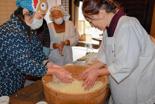 蒸した酒米を手で揉んで冷ます参加者ら＝姫路市網干区余子浜