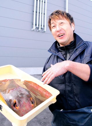 処理する前のアカエイを手に、今後の展望を語る丸魚水産の牧田稔さん＝姫路市白浜町