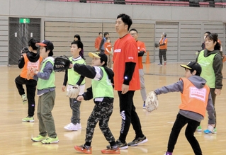 保護者とキャッチボールをする子どもに、優しく助言をする藤川球児さん＝姫路市西延末