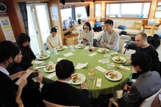 兵庫県産食材を使った料理を船内で味わう参加者たち＝姫路港沖