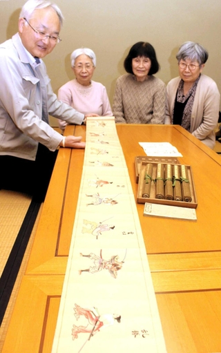 福山藍子さん（右から２人目）が寄贈した巻物を広げて見る学芸員の工藤茂博さん（左端）ら＝姫路市本町