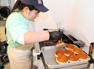 マラサダを揚げる嶋尾朱織さん＝アリイ