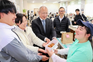 お世話になった先生たちに手作りのマラサダを贈った嶋尾朱織さん（右）＝東中学校