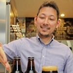 赤穂市産のカキを使った黒ビールを紹介する宮崎隼人さん＝姫路市久保町
