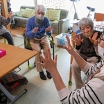 指を曲げ伸ばしする体操に取り組むデイサービス「あけびの輪」の利用者たち＝姫路市南条１
