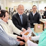 お世話になった先生たちに手作りのマラサダを贈った嶋尾朱織さん（右）＝東中学校