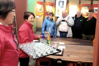 外国人旅行者へ日本酒について説明する灘菊酒造の川石光佐社長（左から２人目）＝姫路市手柄１、灘菊酒造