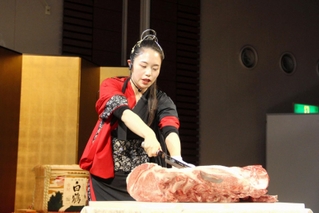 着物姿で和牛をさばくパフォーマンスを見せた渡辺麻莉夏さん＝姫路市南駅前町