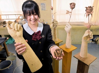 バラを持つ手を表現した作品と、作者の市原心さん＝姫路市香寺町土師、香寺高校