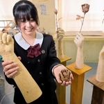 バラを持つ手を表現した作品と、作者の市原心さん＝姫路市香寺町土師、香寺高校