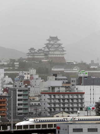 白いベールに覆われた国宝姫路城。市街地とともにかすんで見えた＝姫路市西延末から