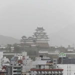 白いベールに覆われた国宝姫路城。市街地とともにかすんで見えた＝姫路市西延末から