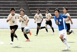 サッカーの試合でボールを追いかける琴陵中と城乾中の選手たち＝姫路市立球技スポーツセンター