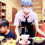 調理した料理を子どもたちに提供する賢明女子学院中学・高校の生徒（中央）＝姫路市二階町