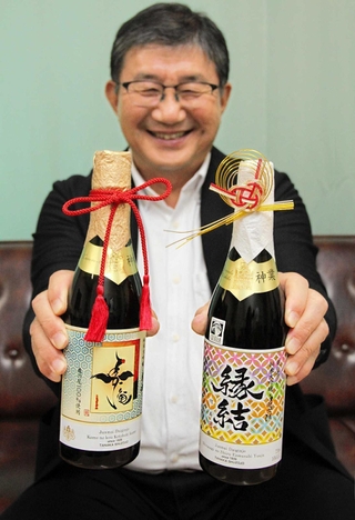 酒米を極限まで磨いた商品を手にする田中酒造場の田中康博社長＝姫路市内