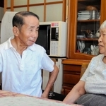 認知症が進む母文子さん（右）を自宅で介護する小林延也さん。親子での会話を大切にする＝姫路市林田町林谷