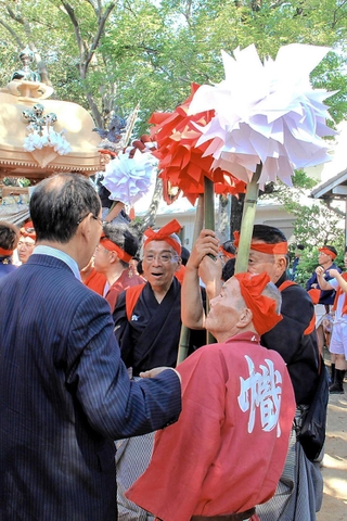秋祭り会場を訪れ、地元住民と言葉を交わす候補者（手前左）＝姫路市飾磨区構