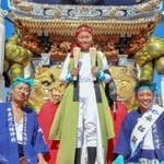 祖父の宮田浩さん（左）、叔父の朋英さん（右）も着用した衣装で、太鼓をたたく乗り子を務める田代銀冬さん（中央）＝武大神社