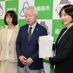 久保田智子教育長（右）に計画書を手渡した加冶佐哲也会長（中央）と尾﨑公子副会長＝姫路市役所北別館