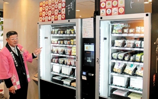 姫路の銘菓を販売する自動販売機を設置した狙いを説明する姫路菓子組合の有元年信理事長＝姫路市南駅前町