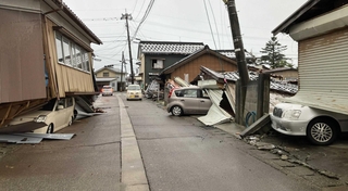 地震で倒壊した建物に挟まれるなどして使えなくなった車＝石川県珠洲市（日本カーシェアリング協会提供）