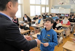 担任から通知表を受け取る児童＝姫路市四郷町坂元、四郷学院