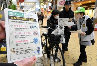 チラシで自転車の盗難防止などを呼びかける姫路署員ら＝姫路市綿町