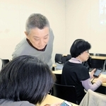 参加者にスマホの読み上げ機能を教える栗川隆宏さん（左奥）＝姫路市総合福祉会館