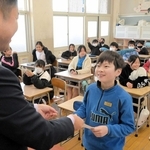 担任から通知表を受け取る児童＝姫路市四郷町坂元、四郷学院