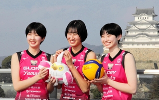 姫路城を背に、ユニホーム姿で写真撮影に応じる（左から）矢田和香選手、秋本美空選手、河俣心海選手＝姫路市本町