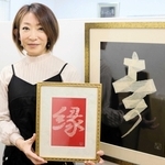 ヘビの抜け殻で制作した「開運アート」を手にする小林るりさん＝姫路市書写