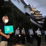 ２０２２年に初めて開かれたナイトツアー。夕暮れの城内で解説する工藤茂博学芸員＝姫路市本町