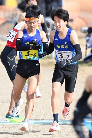 男子・姫路市の６区岸本周真選手（左）からたすきを受け取る７区片山直人選手＝加古川市の加古川河川敷マラソンコース（撮影・斎藤雅志）