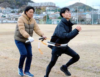 小林直生さん（左）に体の動かし方を教わる成記者＝兵庫県立大学姫路環境人間キャンパス