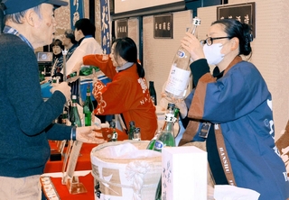 参加者に自慢のお酒を勧める酒蔵の担当者＝姫路商工会議所