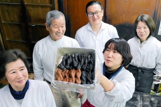 金岡製菓の金岡忠善さん（左から２人目）や直樹さん（同３人目）ら。「油菓子」の商品名で販売している＝姫路市博労町