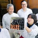 金岡製菓の金岡忠善さん（左から２人目）や直樹さん（同３人目）ら。「油菓子」の商品名で販売している＝姫路市博労町