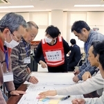 ひめじ防災マイスター（左から３番目）のアドバイスを受けながら図上訓練に取り組む住民ら＝姫路市大津区天満